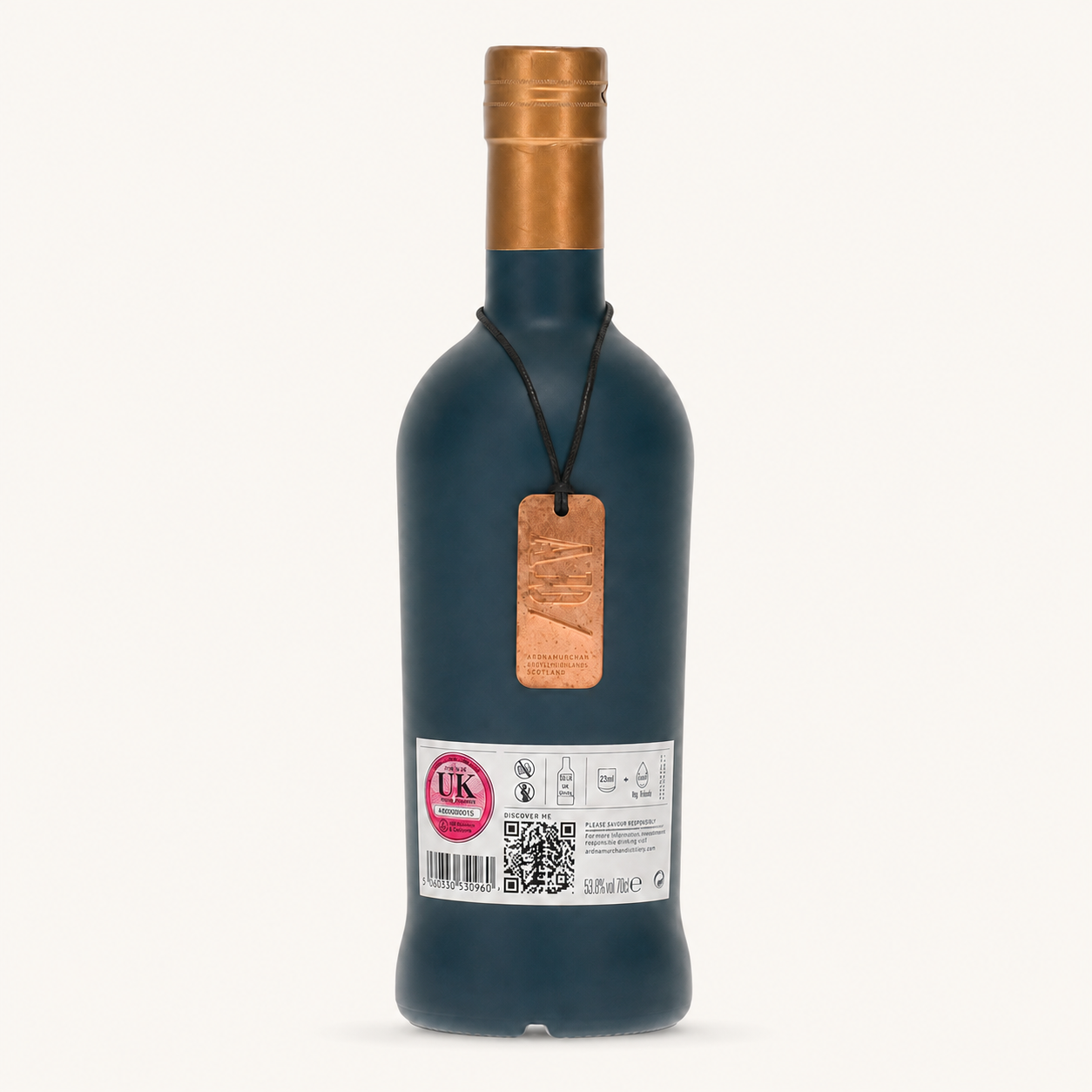 A dark blue glass bottle with a metallic copper-colored foil cap and a hanging copper tag, shown against a plain off-white background.
